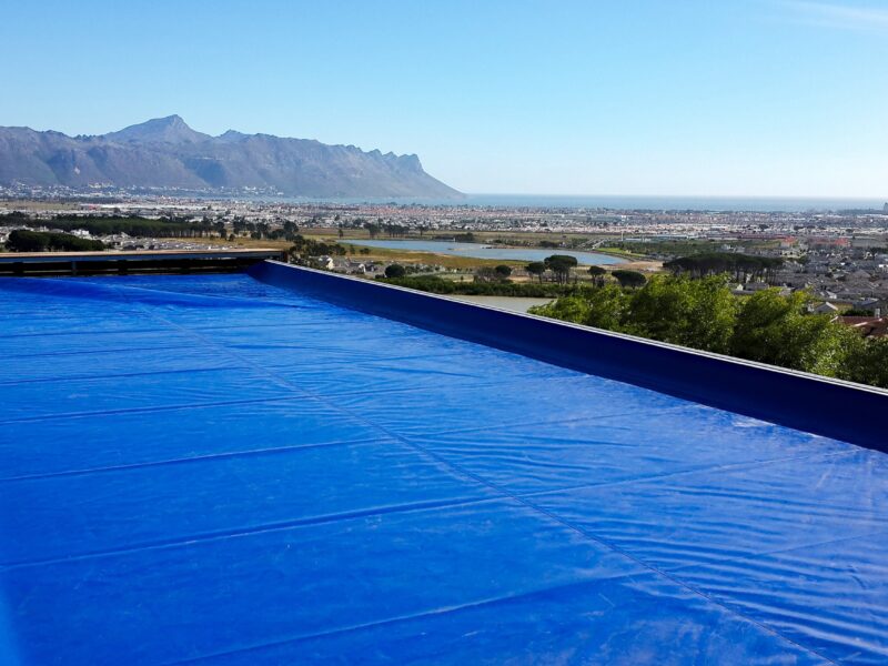 Blue safety cover closed over a pool above Cape Town